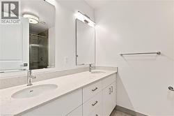 Dual vanity featuring white cabinetry, undermount sinks, and light-toned countertops - 
