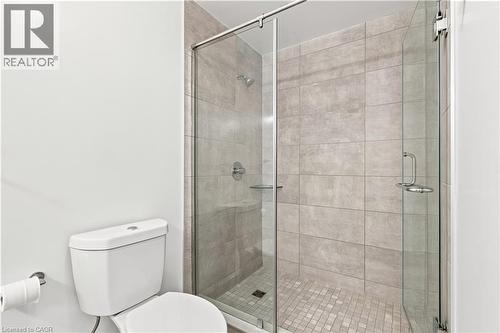 Shower enclosure featuring full-height light gray tiling and a glass door - 50 Grand Avenue S Unit# 713, Cambridge, ON - Indoor Photo Showing Bathroom