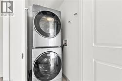 Stacked stainless steel washer and dryer units in a dedicated utility area - 