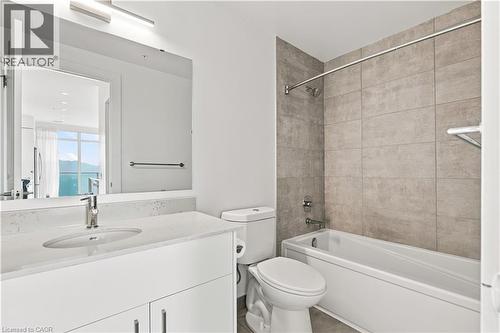 Bathroom featuring a white vanity with an undermount sink and light-toned countertop, a bath-shower combination with full-height tile surround, and a wall-mounted mirror with overhead lighting - 50 Grand Avenue S Unit# 713, Cambridge, ON - Indoor Photo Showing Bathroom