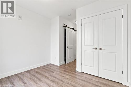 Interior space featuring wood-finish flooring, white baseboards, and bright white walls - 50 Grand Avenue S Unit# 713, Cambridge, ON - Indoor Photo Showing Other Room