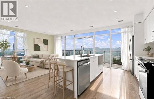 Open-concept living space featuring wood-finish flooring and extensive floor-to-ceiling windows - 50 Grand Avenue S Unit# 713, Cambridge, ON - Indoor Photo Showing Kitchen With Upgraded Kitchen