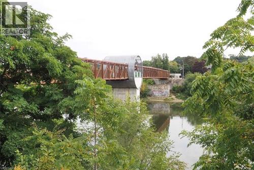 Modern pedestrian bridge with a distinctive enclosed walkway, spanning a serene river - 50 Grand Avenue S Unit# 713, Cambridge, ON - Outdoor