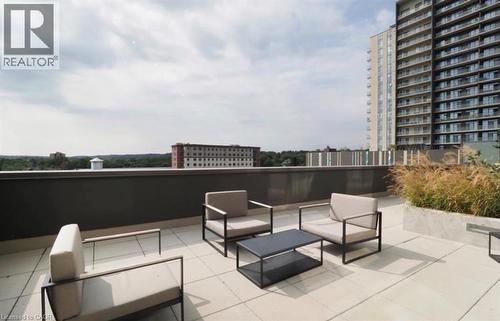 Expansive rooftop patio featuring large format paver tiles and a dark perimeter wall - 50 Grand Avenue S Unit# 713, Cambridge, ON - Outdoor