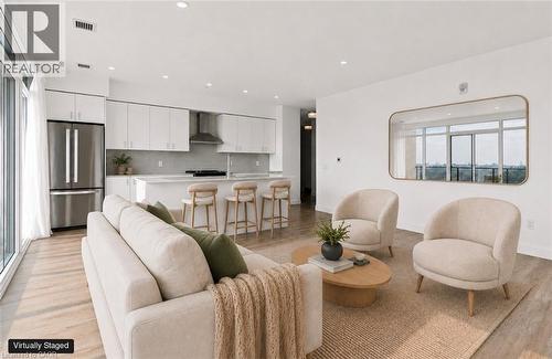 Open-concept living space featuring wood-finish flooring, recessed lighting, and a white kitchen with stainless steel appliances - 50 Grand Avenue S Unit# 713, Cambridge, ON - Indoor