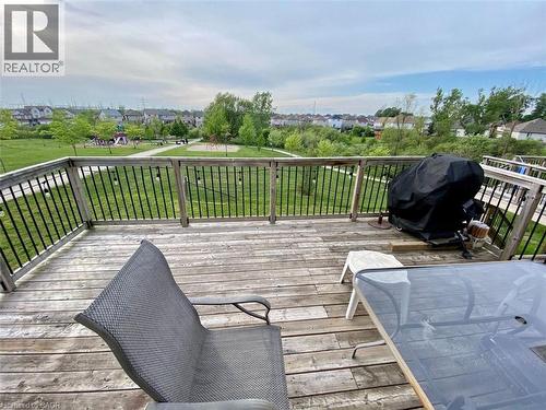 Spacious wood-finish deck with black metal spindle railing overlooking an expansive green space with mature trees - 287 Westmeadow Drive, Kitchener, ON - Outdoor With Deck Patio Veranda