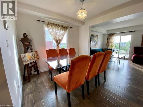 Dining area featuring wood-look flooring and a contemporary chandelier - 287 Westmeadow Drive, Kitchener, ON - Indoor Photo Showing Dining Room