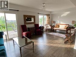 Spacious interior featuring wood-finish flooring, a contemporary chandelier, and white wall finishes - 