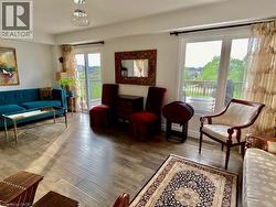 Living space with wood-finish flooring and a contemporary light fixture - 