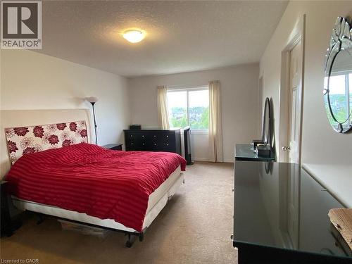 Room featuring a large window with outdoor scenery, neutral-toned walls, and a ceiling-mounted light fixture - 287 Westmeadow Drive, Kitchener, ON - Indoor Photo Showing Bedroom