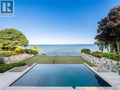 Infinity-edge swimming pool with integrated steps and a surrounding stone patio - 140 Secord Lane, Burlington, ON - Outdoor With Body Of Water With In Ground Pool With View