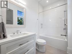 Bathroom featuring a white vanity with an integrated sink, polished chrome faucet, and a framed mirror - 