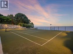 Tennis court featuring a synthetic grass surface, white court lines, and a black net - 