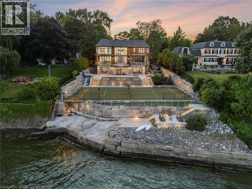 Waterfront property featuring a multi-level terraced landscape with stone retaining walls - 140 Secord Lane, Burlington, ON - Outdoor With Body Of Water With Deck Patio Veranda