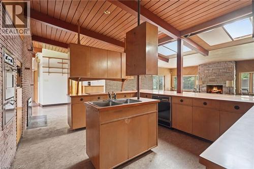 Open-concept kitchen area featuring wood-finish cabinetry, integrated oven and dishwasher, and an expansive countertop - 264 Mountain Brow Boulevard, Hamilton, ON - Indoor Photo Showing Kitchen With Double Sink