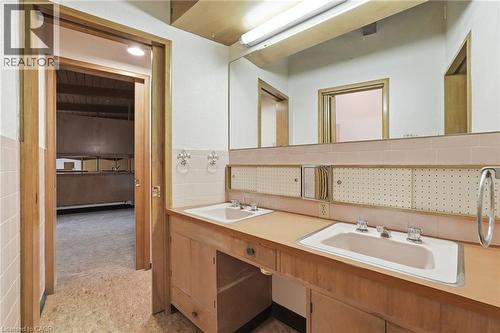 Bathroom vanity featuring dual sinks, wood-finish cabinetry, and a full-width mirror - 264 Mountain Brow Boulevard, Hamilton, ON - Indoor Photo Showing Bathroom