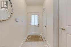 Entryway featuring light-toned tile flooring, white baseboards, and neutral wall paint - 