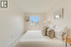 Neutral-toned room featuring a single window, recessed ceiling lighting, and light-colored carpeting - 