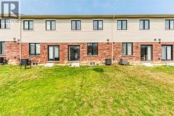 Rear exterior featuring a brick and siding facade with multiple windows and glass doors, providing abundant natural light - 