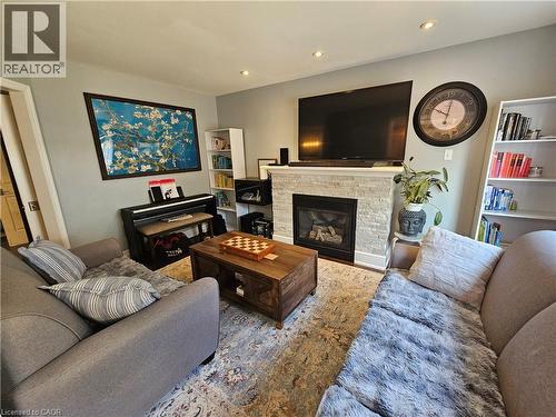 Living room with a glass covered fireplace, and recessed lighting - 20 Bird Court, Cambridge, ON - Indoor Photo Showing Living Room With Fireplace