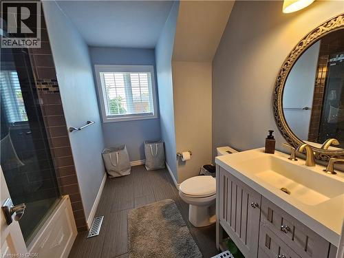 Family Bathroom - Full bath featuring vanity, wood finished floors, and bath / shower combo with glass door - 20 Bird Court, Cambridge, ON - Indoor Photo Showing Bathroom
