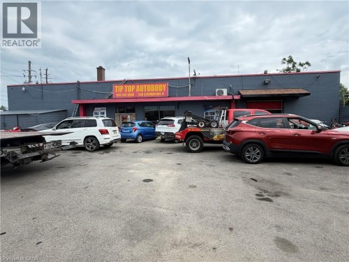 Commercial building featuring a dark gray facade with red trim and a prominent business sign - 350 Sherman Avenue N, Hamilton, ON 