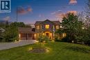 Stone facade residence featuring a two-car garage, mature landscaping, and an expansive front lawn - 5779 Third Line, Guelph/Eramosa, ON  - Outdoor 