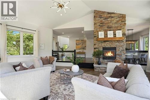 Vaulted ceiling living area featuring a stone-clad fireplace with a wood mantel, wood-finish flooring, and recessed lighting - 5779 Third Line, Guelph/Eramosa, ON - Indoor Photo Showing Living Room With Fireplace