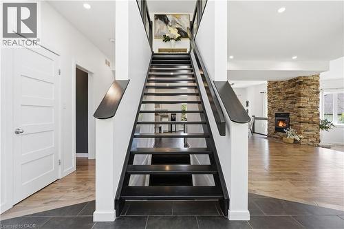 Modern staircase with dark wood-finish treads and railings - 5779 Third Line, Guelph/Eramosa, ON - Indoor Photo Showing Other Room With Fireplace