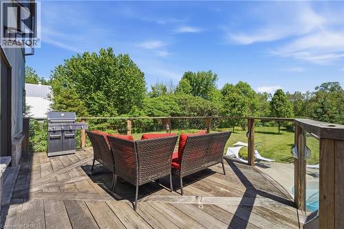 Expansive outdoor deck featuring weathered wood flooring, a stainless steel grill, and a wood and glass railing system - 5779 Third Line, Guelph/Eramosa, ON - Outdoor With Deck Patio Veranda