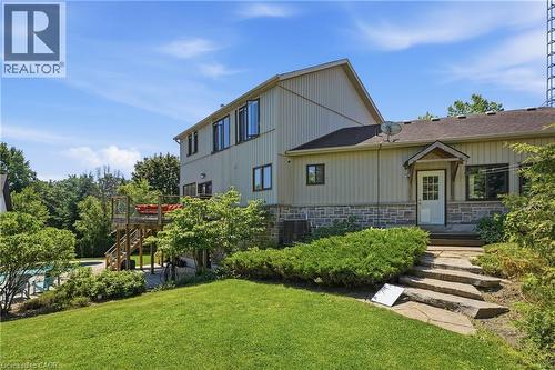 Exterior featuring stone veneer and vertical siding, multi-level wood deck, and a natural stone staircase - 5779 Third Line, Guelph/Eramosa, ON - Outdoor