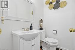 Powder room featuring a white vanity with integrated sink, brushed nickel faucet, and a large framed mirror - 