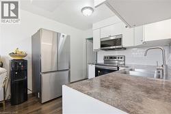 Modern kitchen featuring white cabinetry, stainless steel appliances, and a subway tile backsplash - 