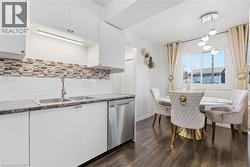 Contemporary kitchen featuring white cabinetry, a double basin sink with a chrome faucet, and a stainless steel dishwasher - 