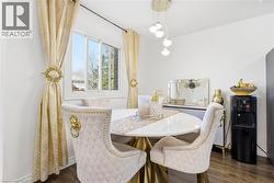 Dining area featuring wood-finish flooring, a contemporary pendant light fixture, and a white framed window - 