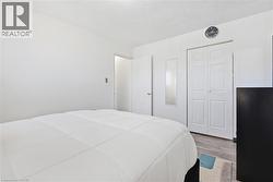 Spacious room featuring white walls, bi-fold closet doors, and wood-finish flooring - 
