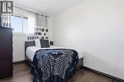 Bedroom featuring wood-finish flooring and a white ceiling - 