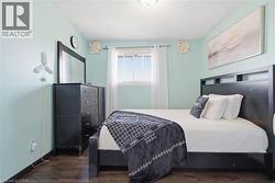 Room featuring wood-finish flooring and light blue walls - 