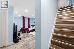 Wood-finish stairs with white risers and light blue wall color - 