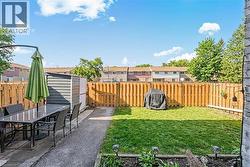 Fenced backyard featuring a gravel patio, storage shed, and a manicured lawn - 