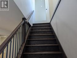 Hardwood stairs with frosted glass door at top of stairs - 