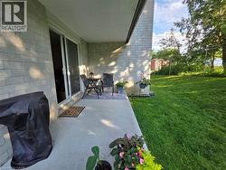 Covered patio featuring a concrete surface and light-toned brick exterior - 