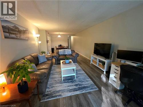 Spacious living area featuring wood-finish flooring throughout - 24 Mooregate Crescent Unit# 103, Kitchener, ON - Indoor Photo Showing Living Room