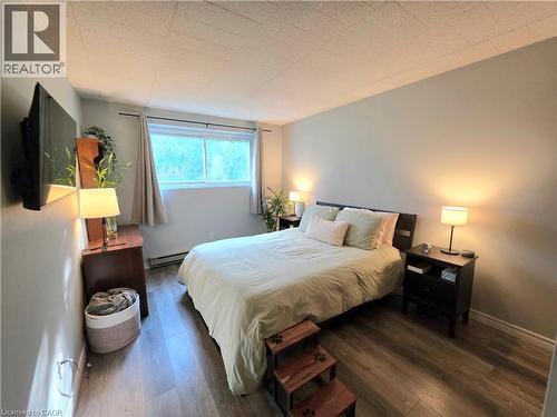 Bright room featuring wood-finish flooring and light gray walls - 24 Mooregate Crescent Unit# 103, Kitchener, ON - Indoor Photo Showing Bedroom