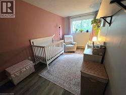Room featuring wood-finish flooring, a window with natural light, and a wall-mounted shelving unit - 