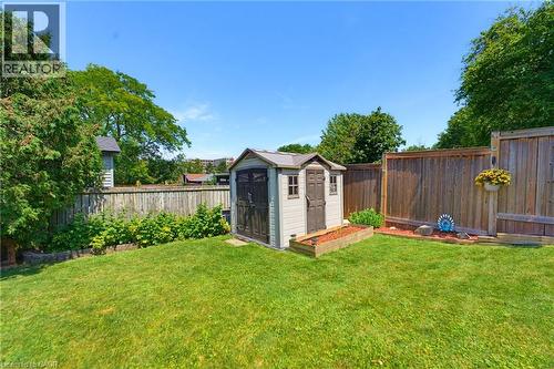 Expansive green lawn featuring a storage shed, wood privacy fencing, and mature perimeter trees - 164 Hanover Place, Hamilton, ON - Outdoor