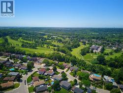 Aerial perspective showcasing a residential area bordered by an expansive golf course - 