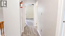 Hallway featuring wood-finish flooring and light-toned wall paint - 