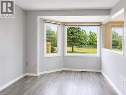 Bay window feature with multiple panes, wood-finish flooring, white baseboards, and neutral wall paint - 