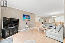 Bright open-concept, sunken living area featuring light hardwood flooring, - 